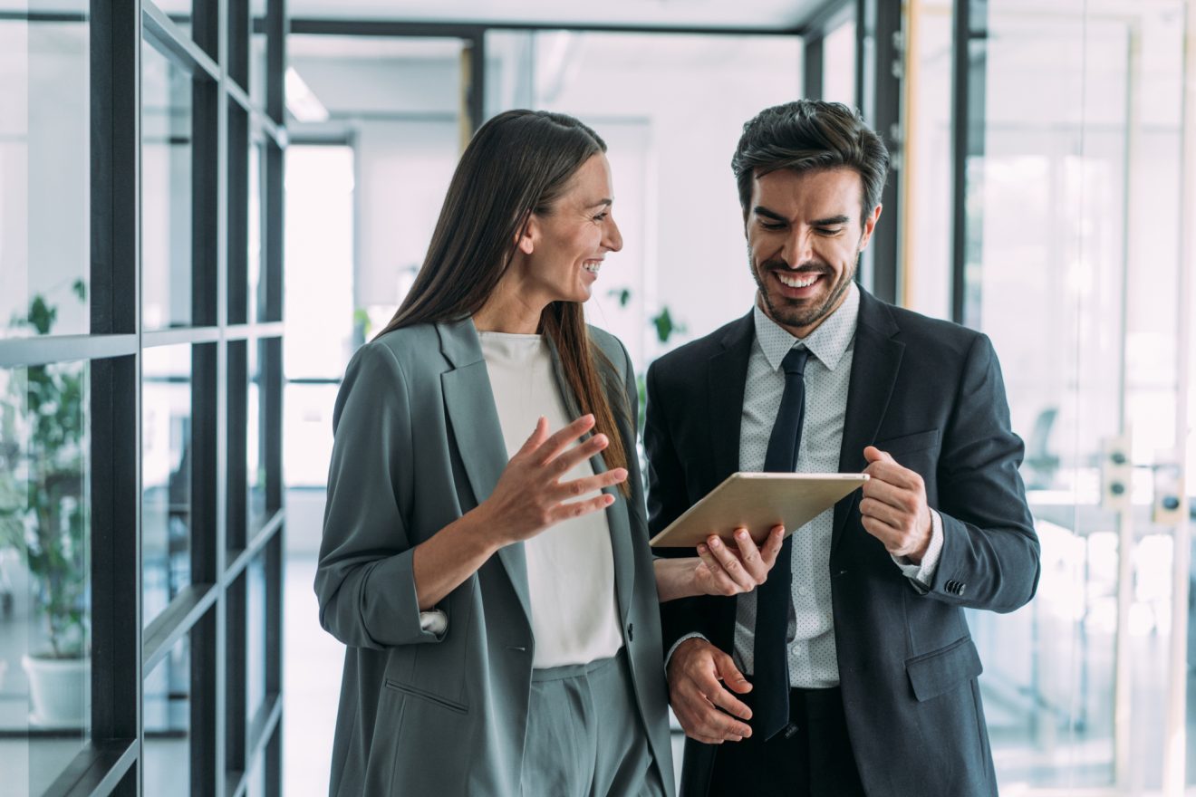 Businessman and businesswoman in meeting using digital tablet and discussing business