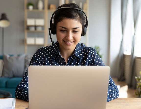 woman at laptop with headset on