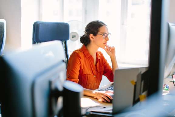 Pensive woman working at computer in office